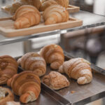 Fresh croissants and pastries displayed in a bakery case, evoking the kind of fragrant sensory experience that sparks creative inspiration